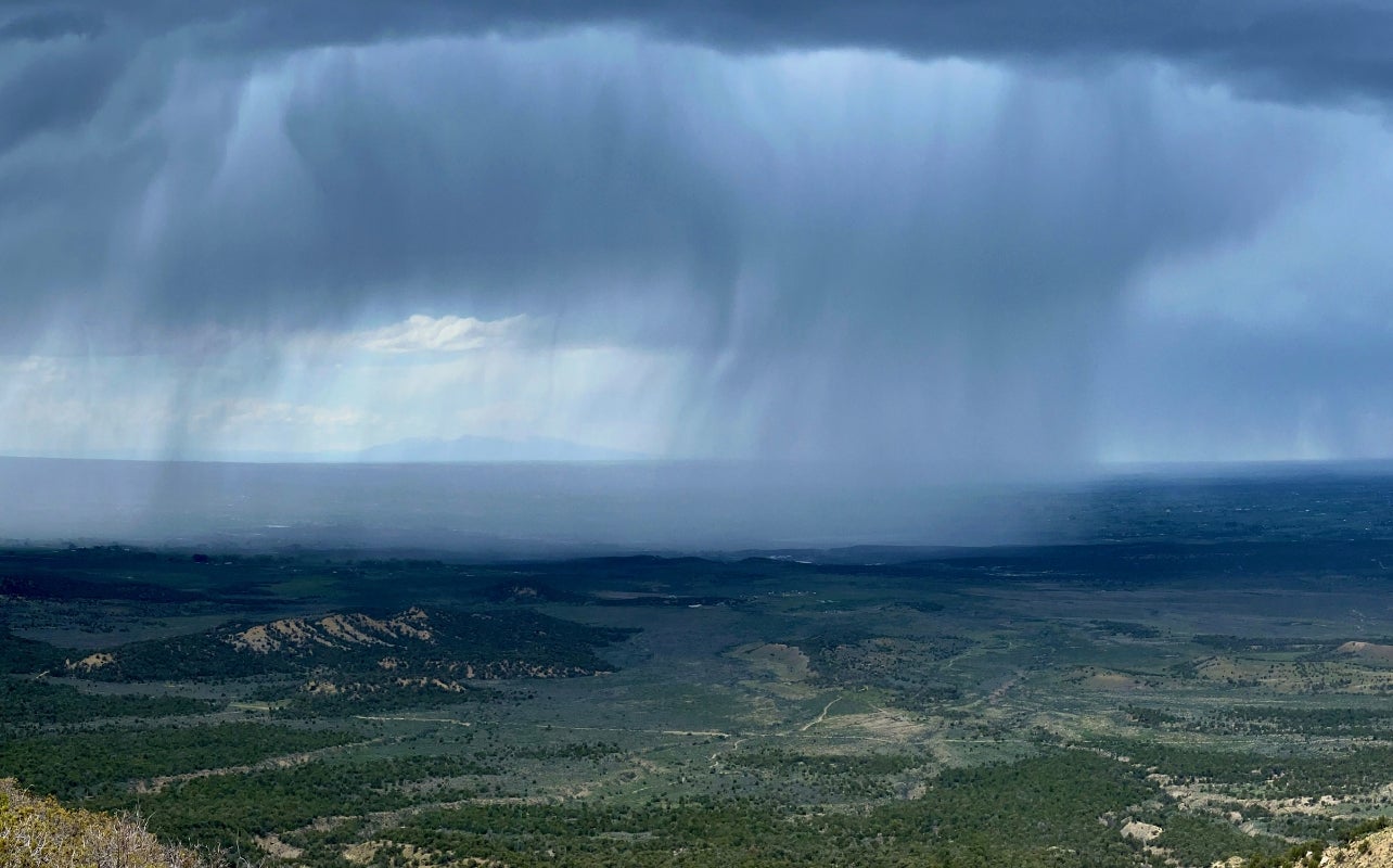 A rainstorm in the distance over a southern Colorado landscape.